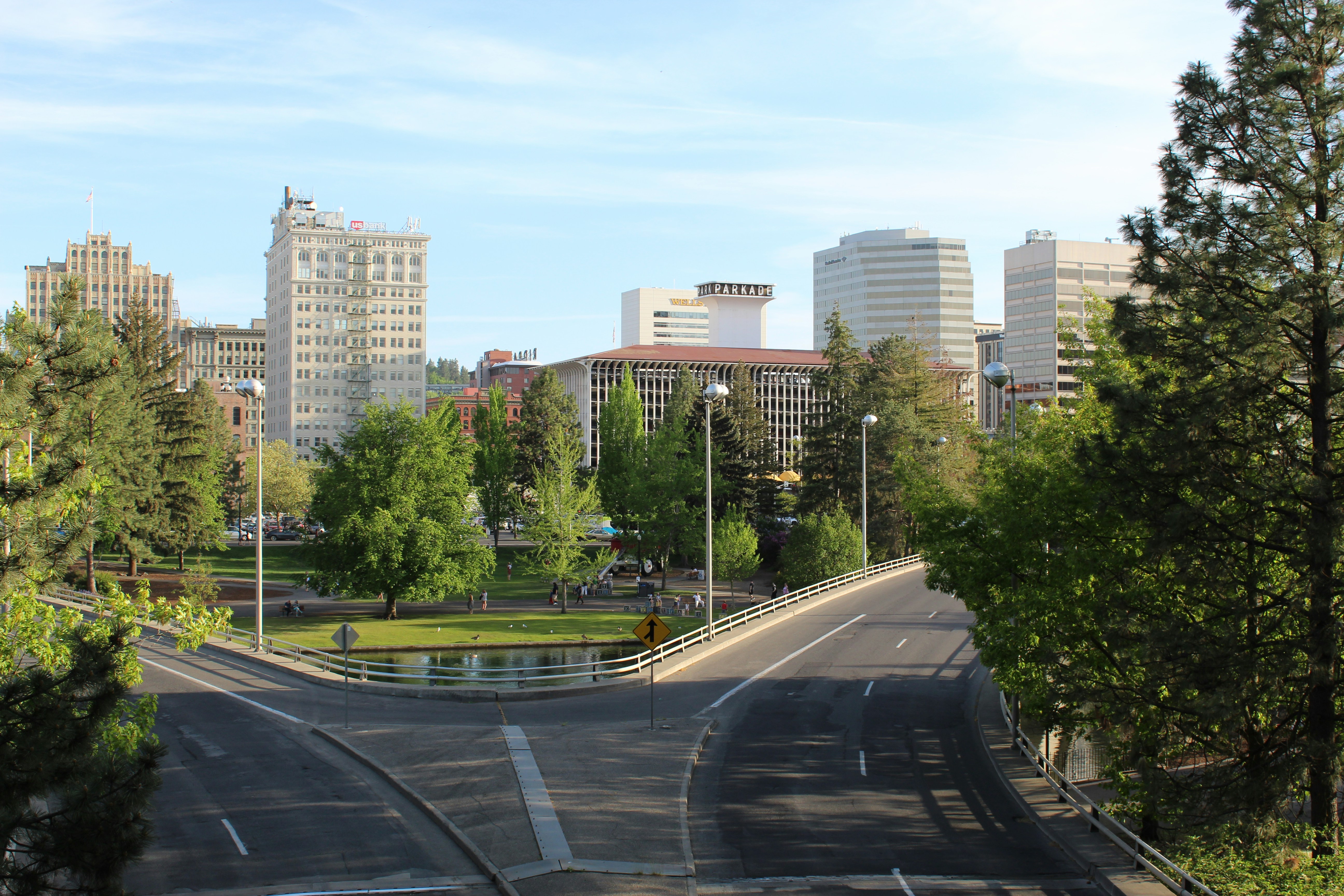 ALT= Debt Collection Agency in Spokane Washington + picture of downtown Spokane WA + highway roads + green trees + buildings + blue sky