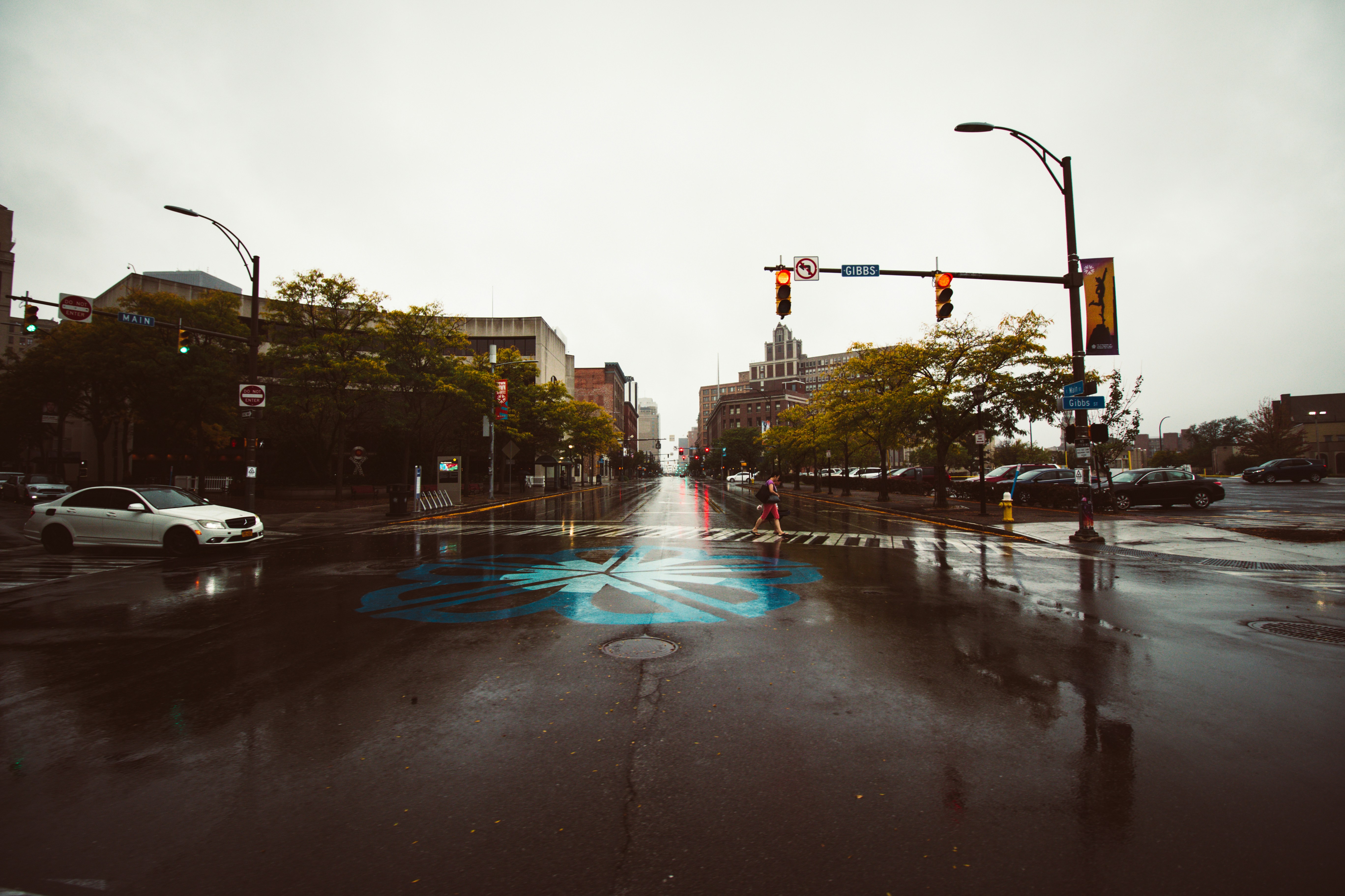 ALT= Debt Collection Agency in Rochester New York + streets in Rochester + blue paining on the street after a rain + street light + car driving