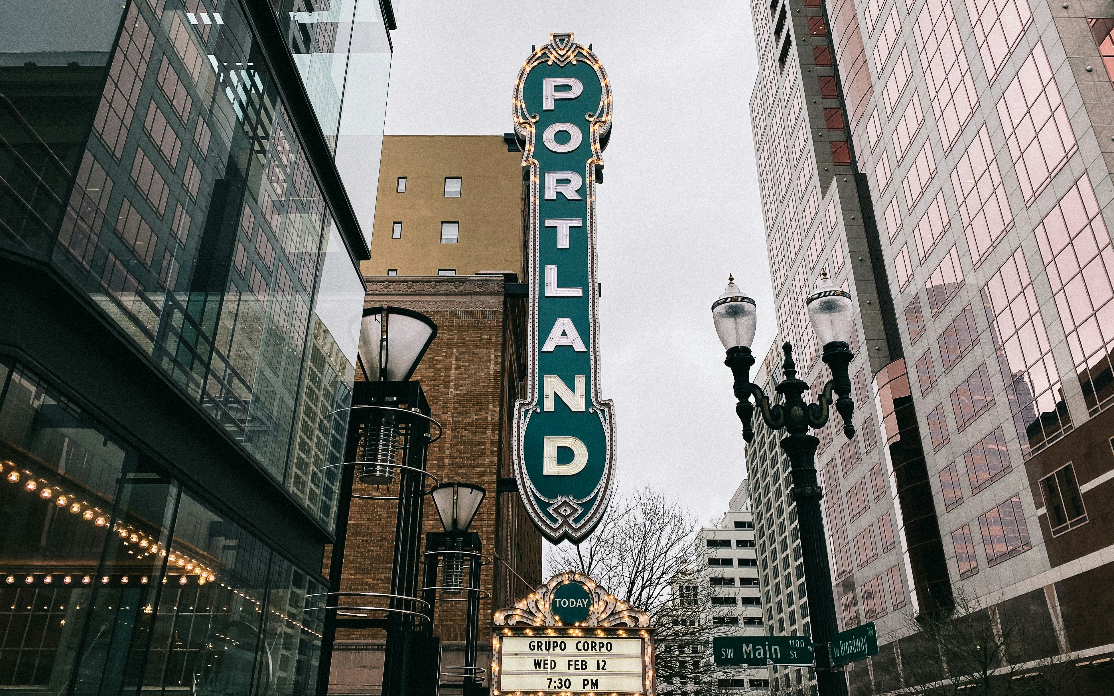 ALT= Debt Collection Agency in Oregon + picture + downtown Portland Oregon + green sign on building that reads (PORTLAND) + buildings + theater