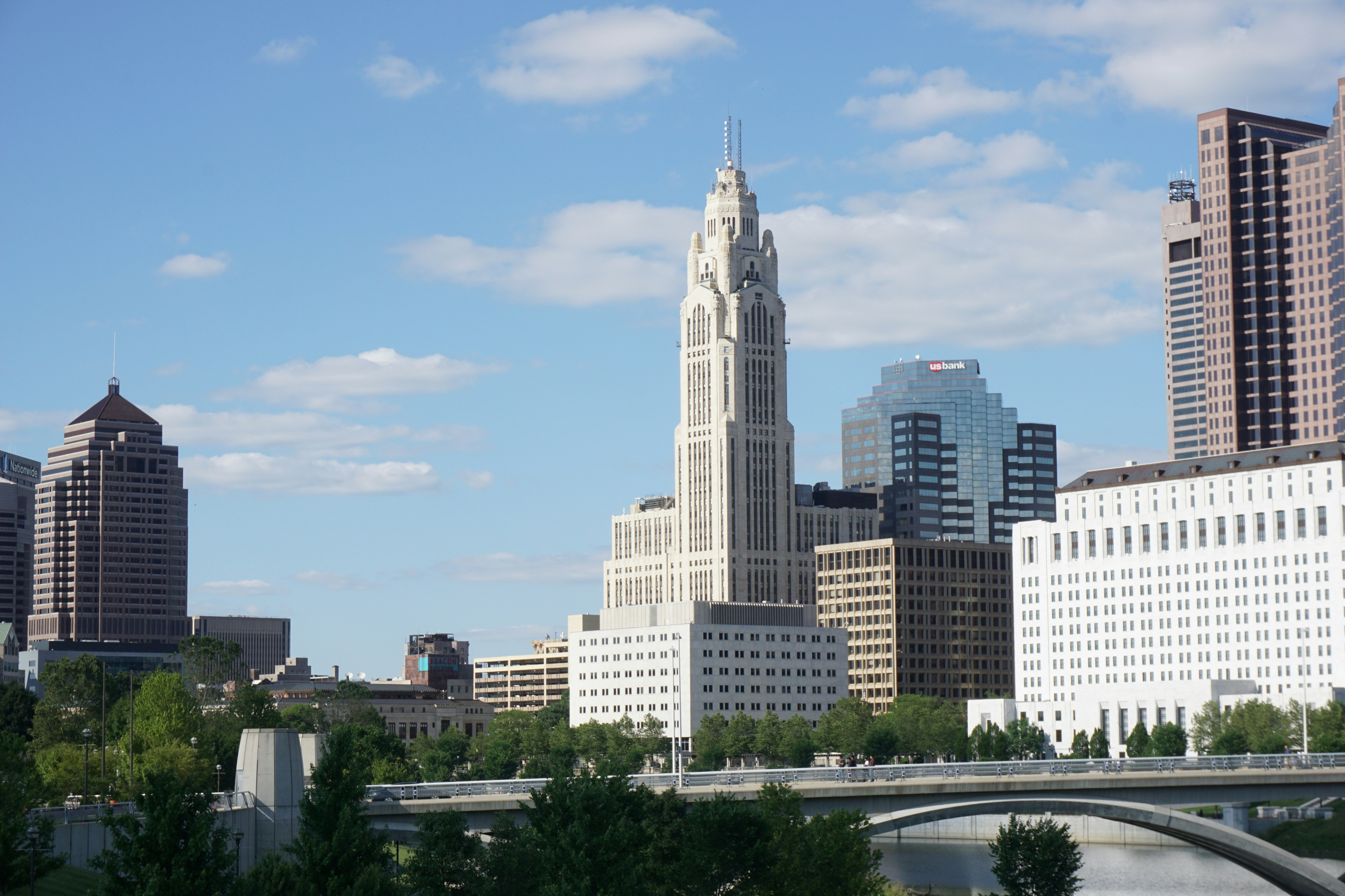 ALT= Debt Collection Agency in Columbus Ohio + pictures of buildings in Columbus OH + bridge + green trees + blue sky with clouds