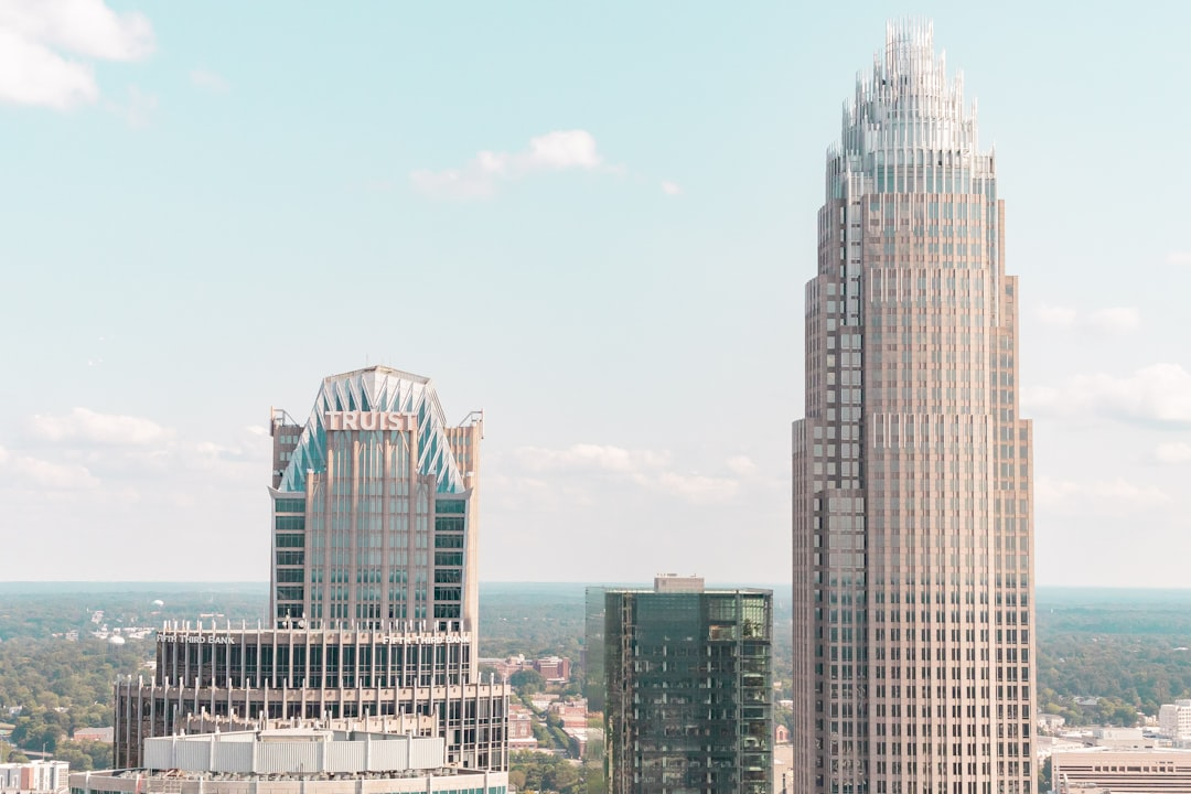 ALT= Debt Collections Agencies Charollte North Carolina + Buildings in charlotte looking + straight up view + blune + purple + orange color in sky