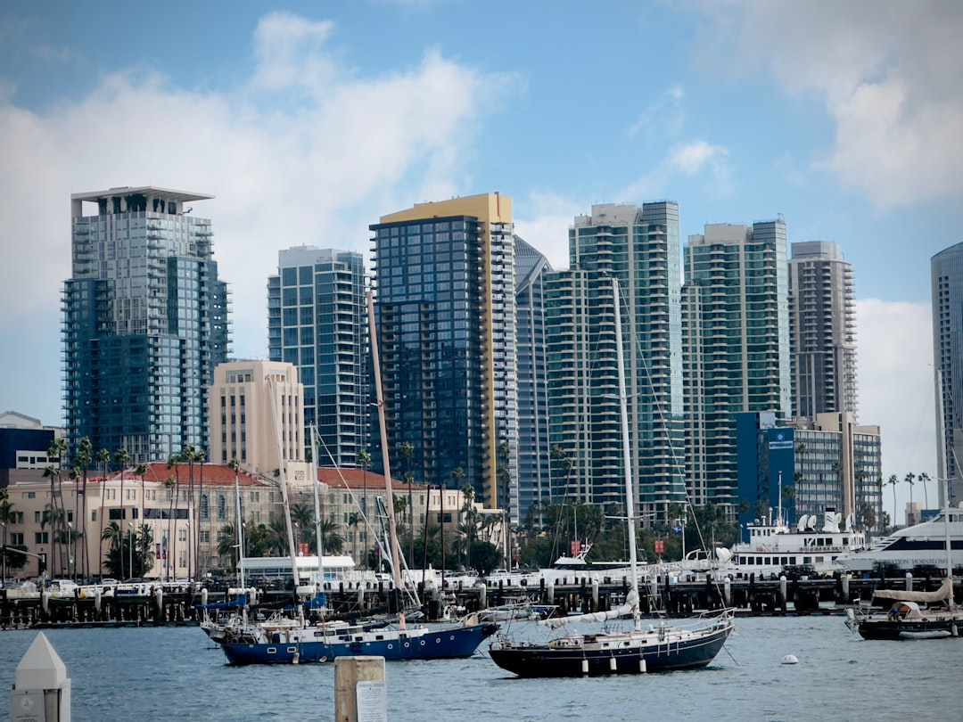 ALT= Debt Collection Agency San Diego California + picture of downtown buildings from the bay + sail boats+ blue sky with clouds