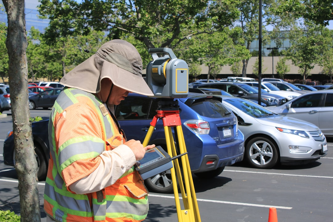 ALT= Debt Collections Special Services + picture + land survey + man in orange + working + parking lot