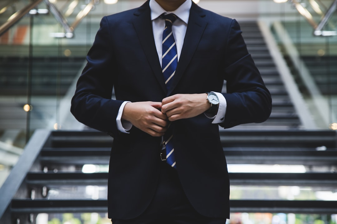 ALT= Debt Collections for small businesses + picture + small business owner in suit + walking downstairs + in office building